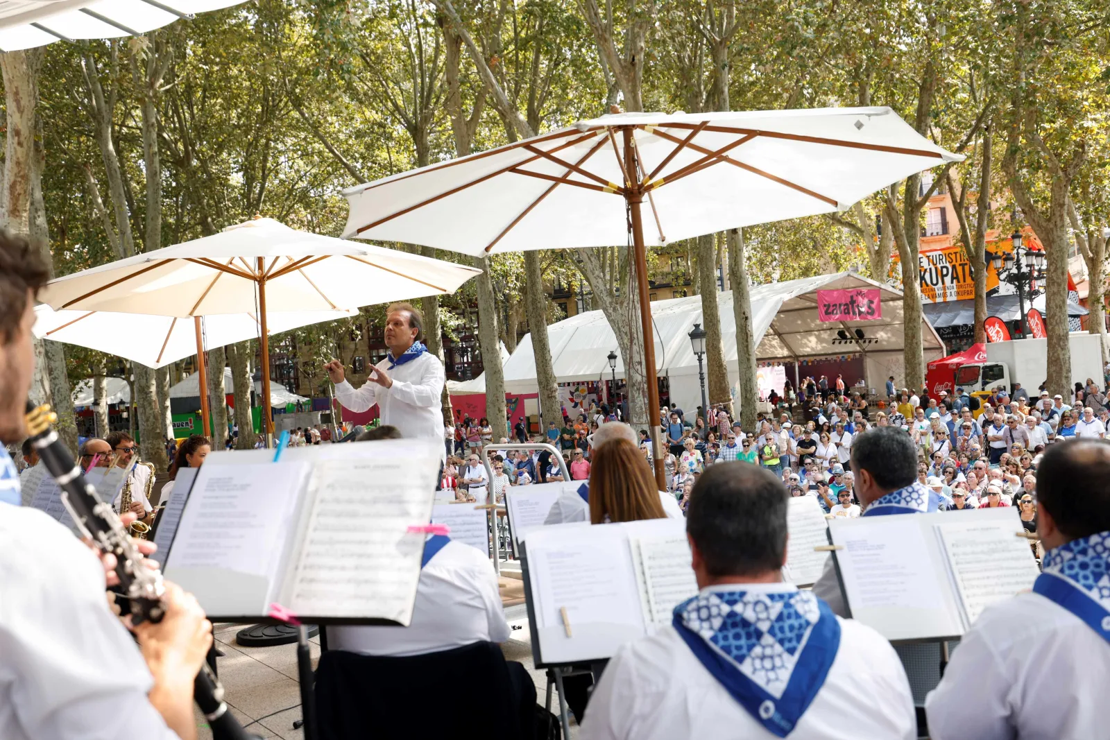Músicos y público ante el kiosco del Arenal, bajo las sombrillas