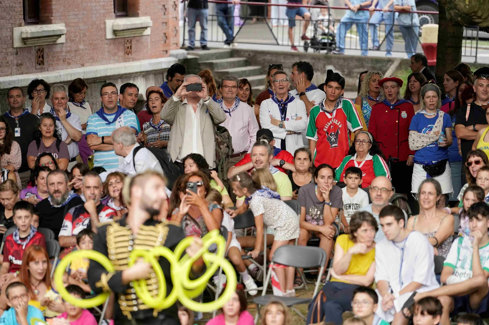 Público con pañuelos de Aste Nagusia al cuello sigue la función de pie y sentado en los jardines del hospital