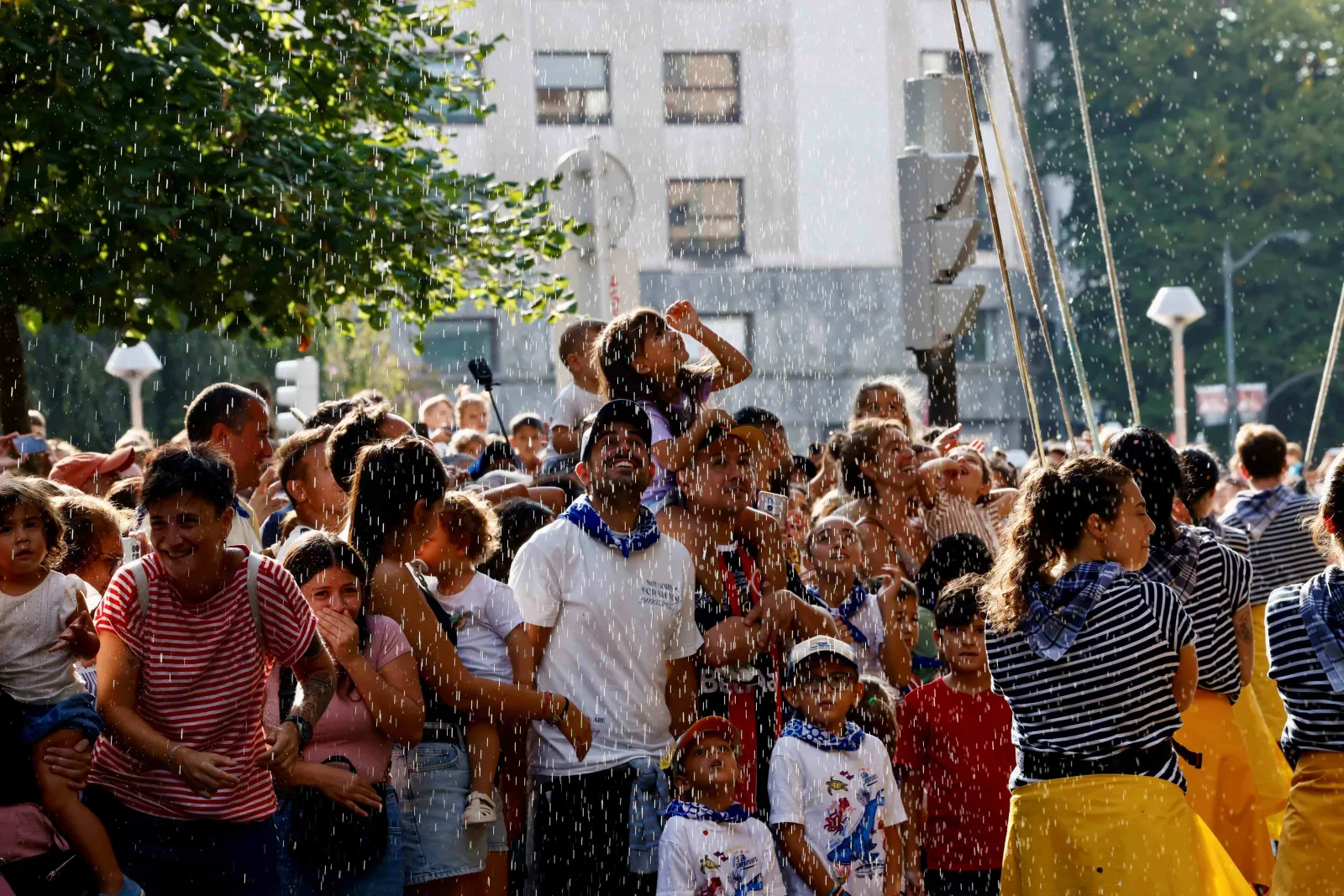 El público del desfile recibe chorros de agua en la Gran Vía
