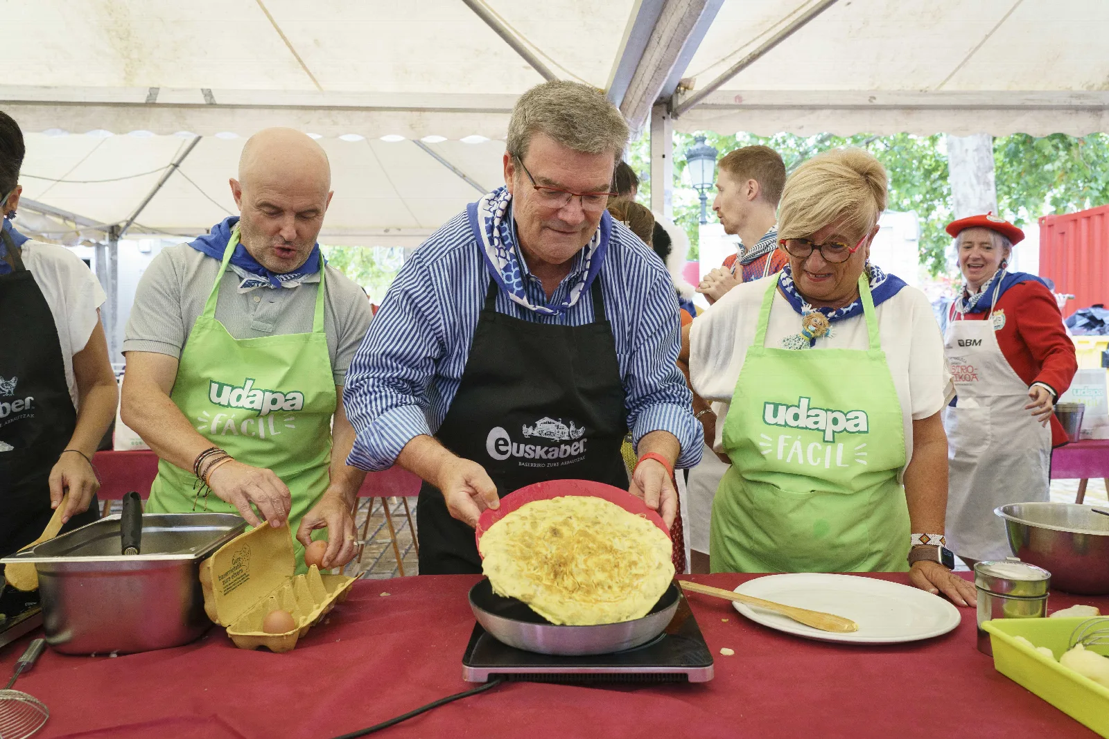 Una tortilla de patata ya cuajada dentro de la sartén, sobre la mesa del certamen