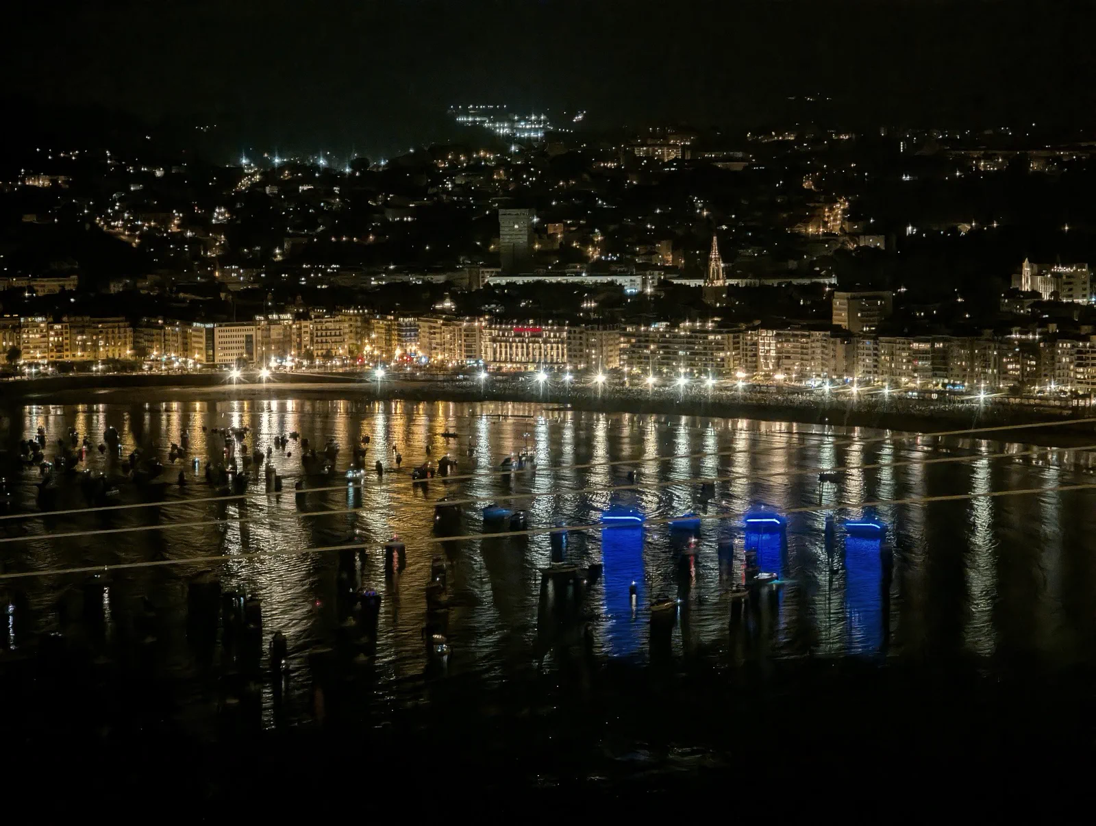 La bahía de la Concha ya de noche vista desde el Asador Alaia, con el paseo iluminado y las luces reflejadas en el agua