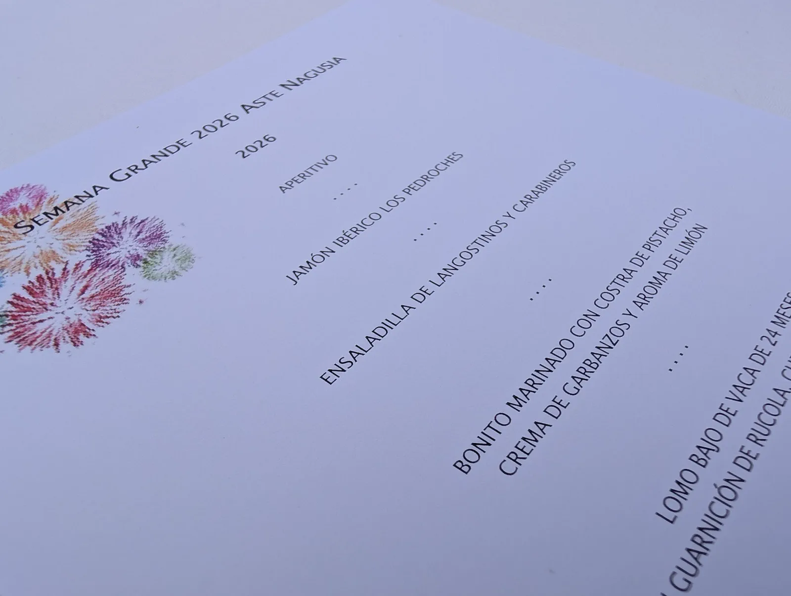 La carta del menú de Semana Grande 2026 del Restaurante La Perla sobre el mantel de la mesa