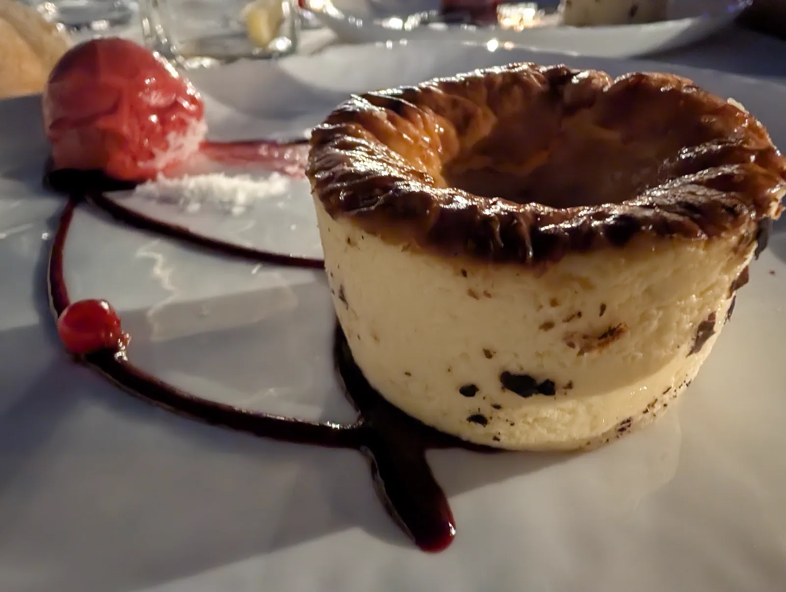 Tarta de queso con frutos rojos e hibiscos junto a una bola de sorbete de frambuesa y un trazo de coulis, postre del menú de La Perla