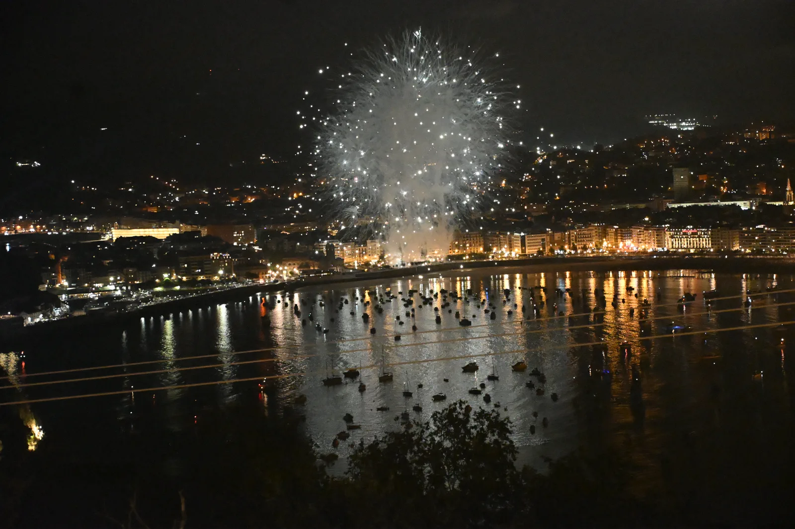 Gran esfera blanca de fuegos artificiales abriéndose sobre Donostia en el tramo final de la tanda de Phoenix Fireworks