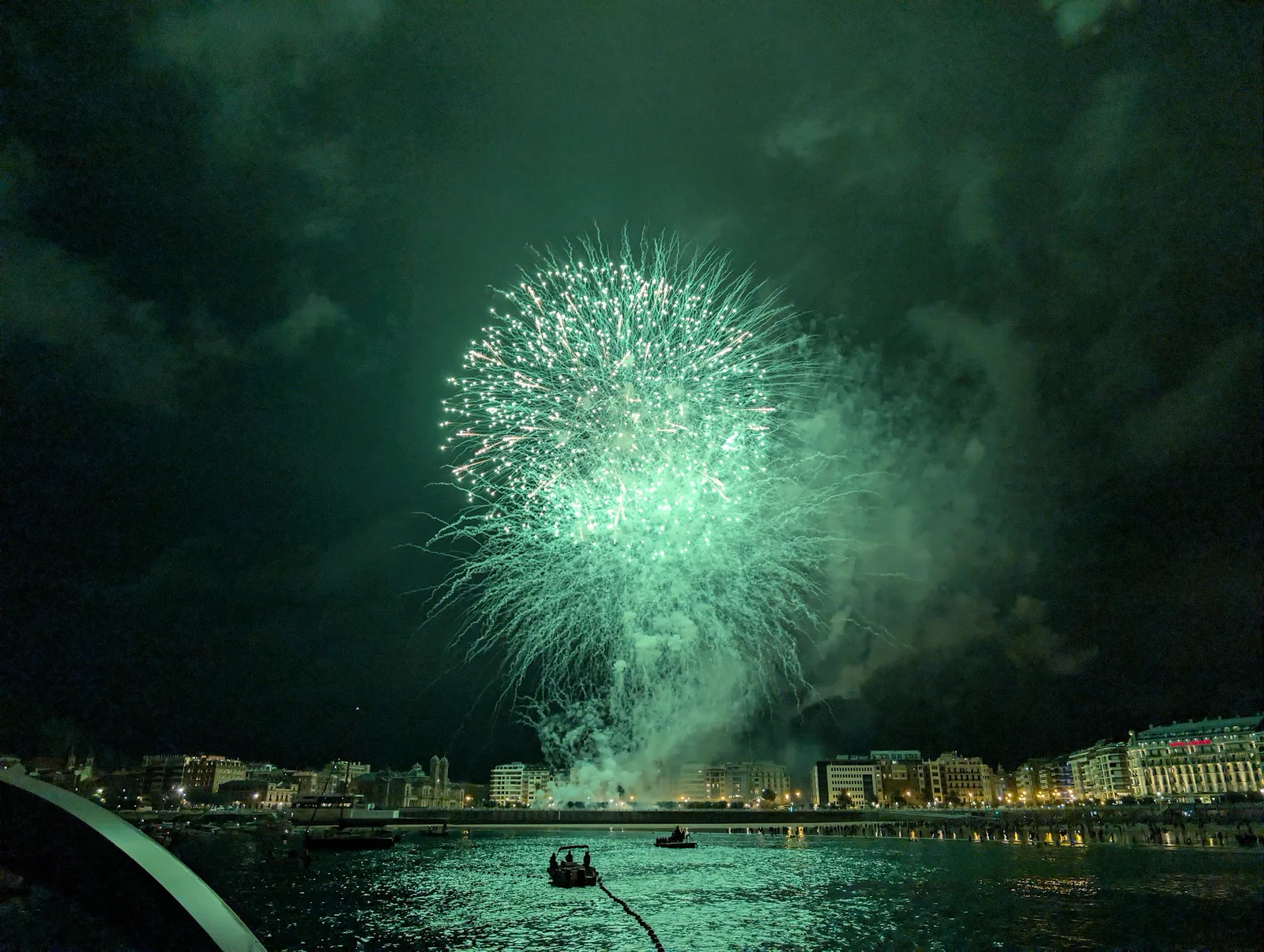 Gran esfera verde abriéndose sobre el centro de la bahía, con el agua teñida de verde
