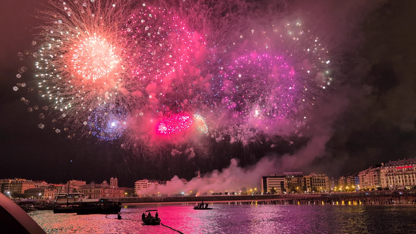 Gran estallido rojo y rosa que tiñe de color la bahía y las nubes bajas
