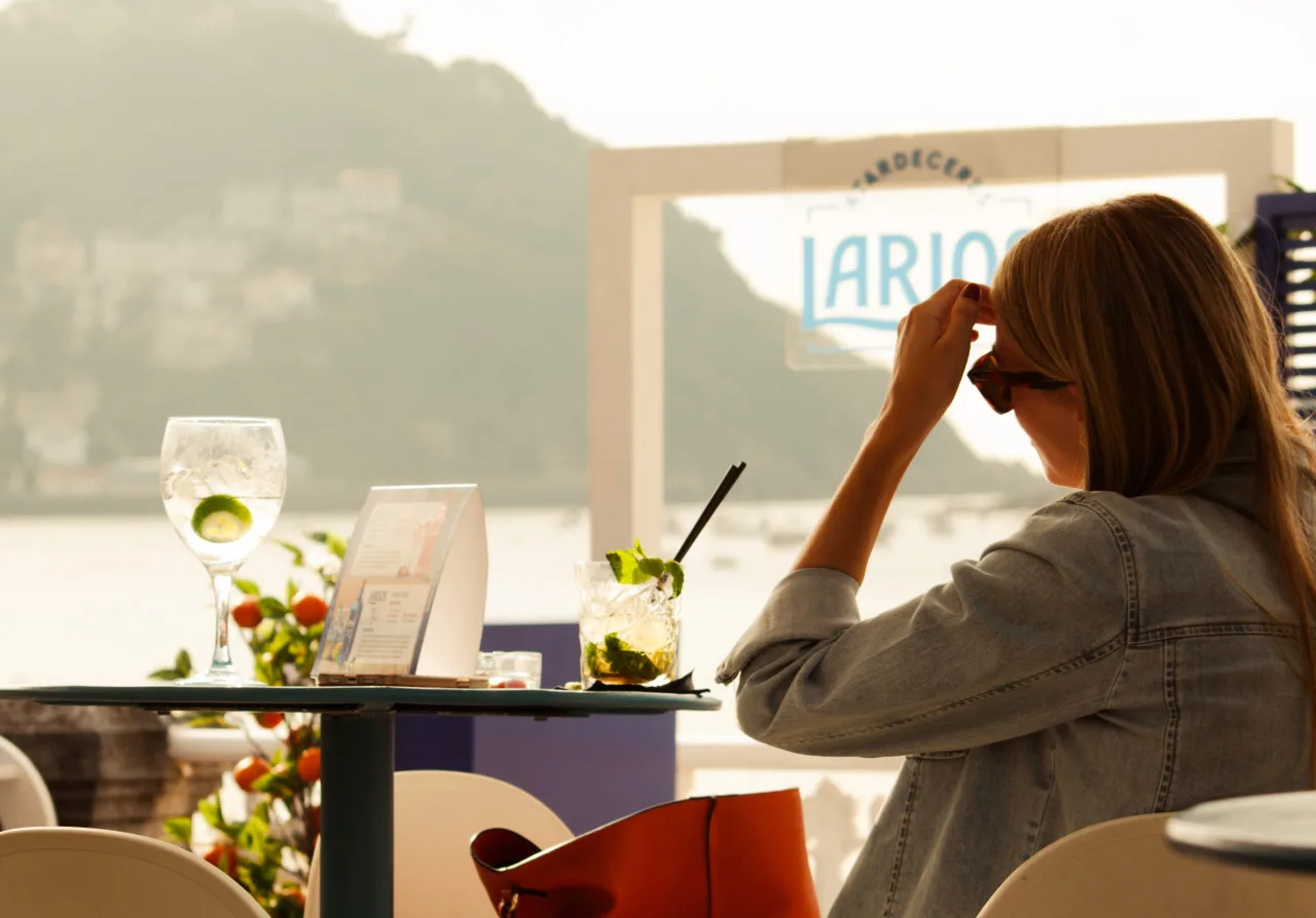 Terraza del Bataplán al atardecer, con una copa sobre la mesa y la bahía de la Concha al fondo
