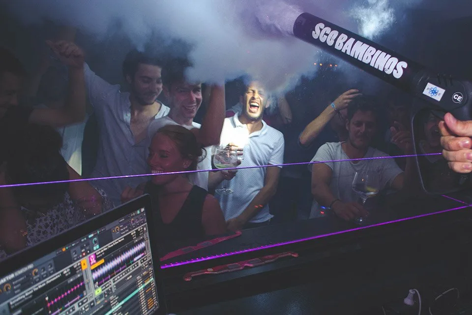 Ambiente de fiesta en la pista del GU San Sebastián, con público bailando junto a la cabina de DJ
